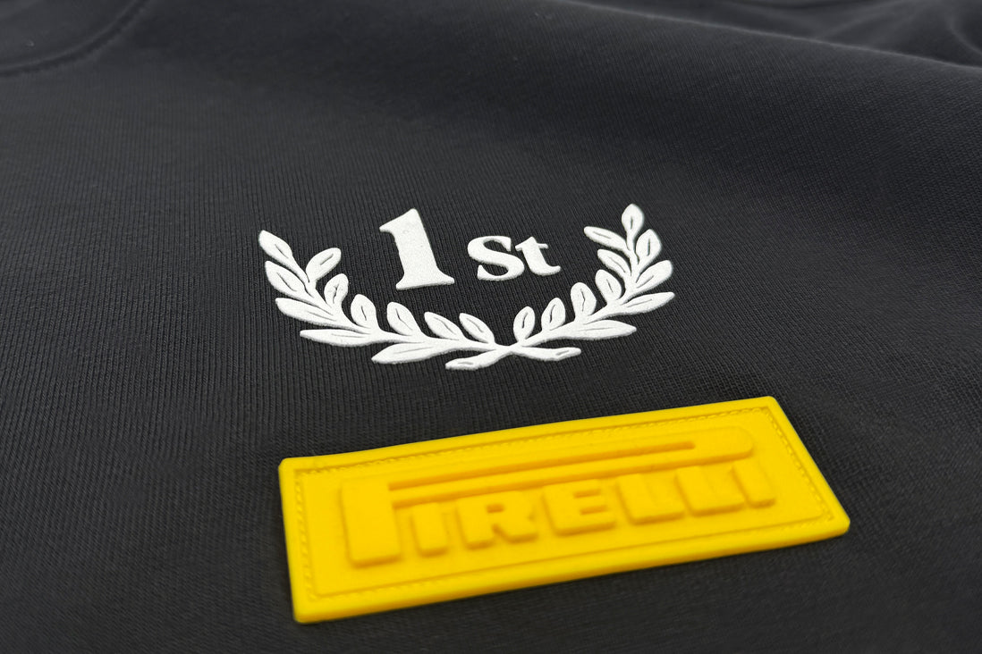 Black fabric with '1st' and Pirelli laurel wreath design