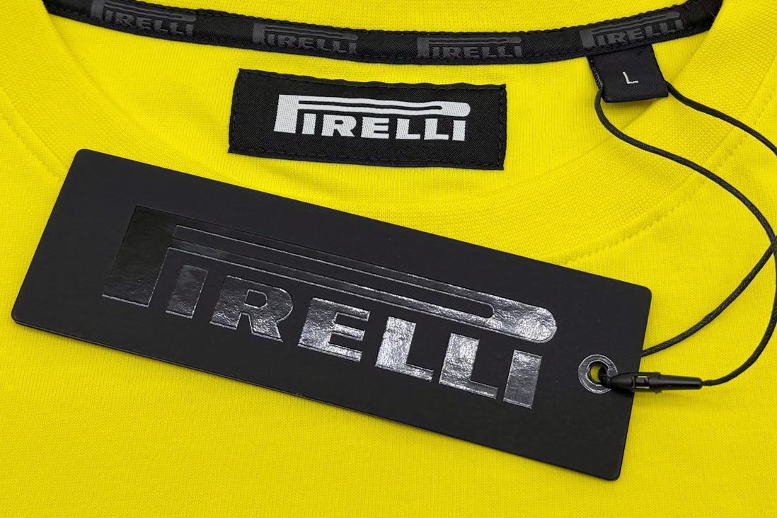 Pirelli clothing labels on a yellow background with a black tag.