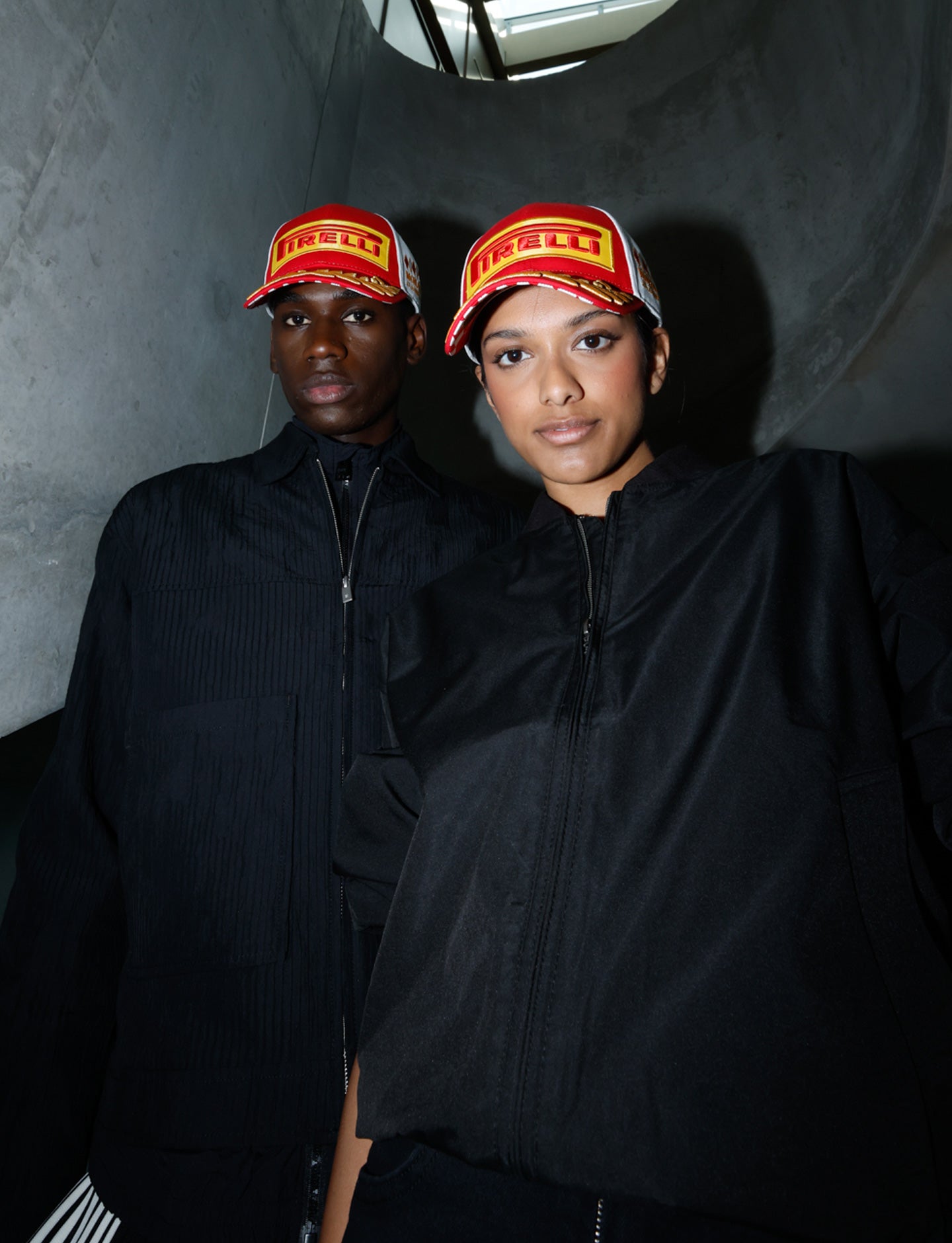 man and woman in red & white Pirelli Podium Cap