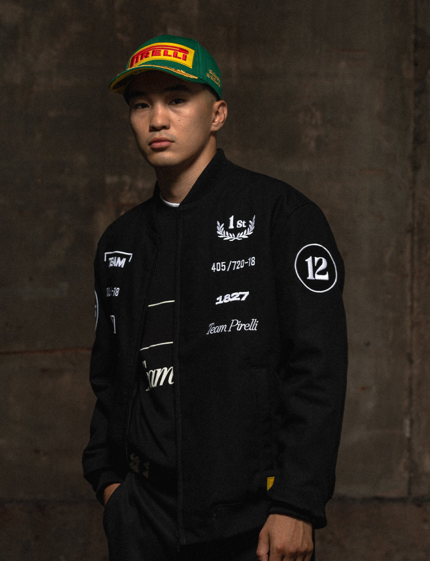 man in Pirelli racing jacket wearing green Pirelli podium cap
