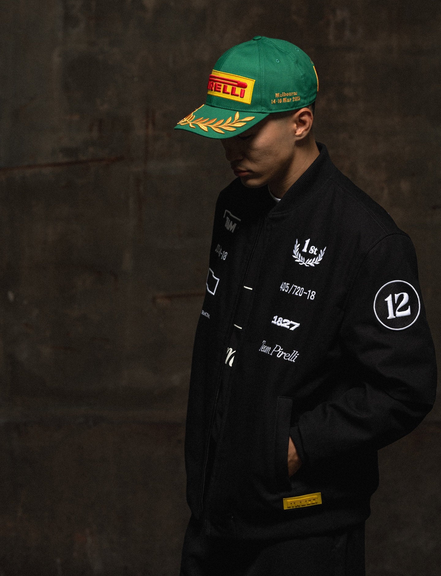 man in Pirelli racing jacket wearing green Pirelli podium cap