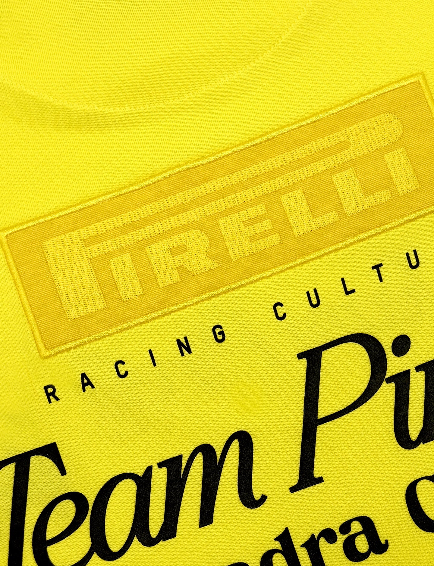 Close-up of a yellow shirt with Pirelli branding and text.