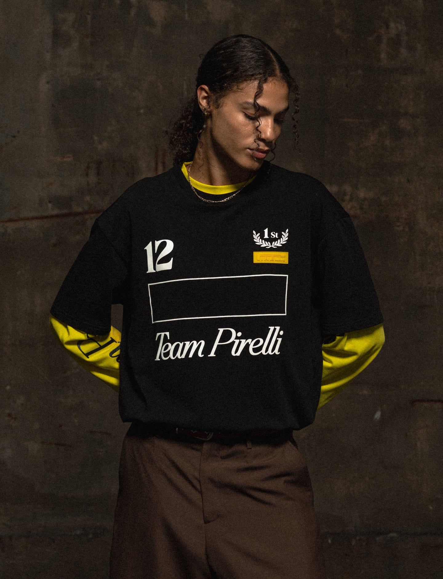 Person wearing a black and yellow 'Team Pirelli' sweatshirt against a dark background