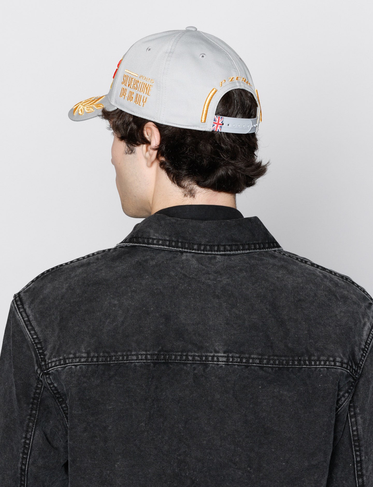 Man in silver Pirelli Podium cap