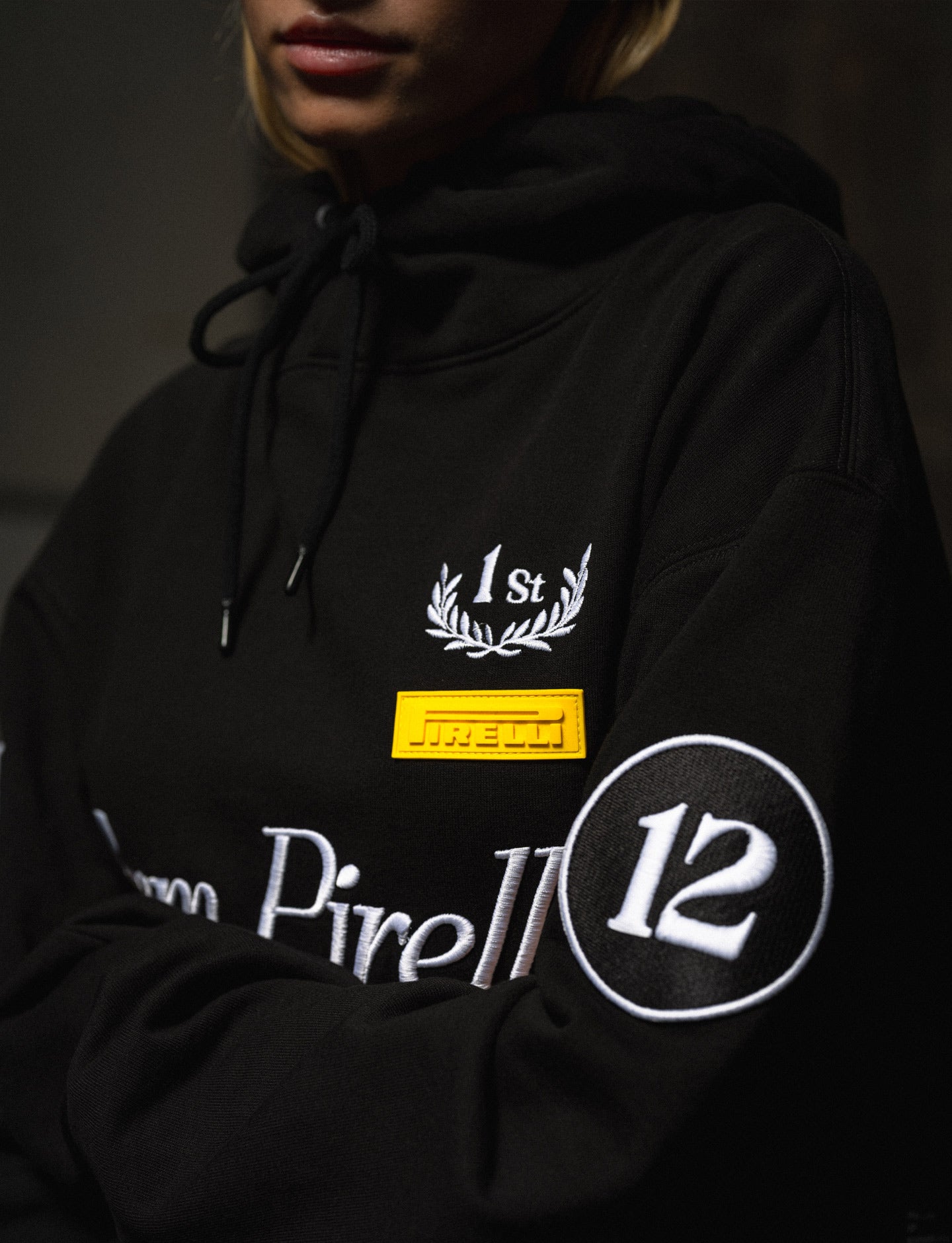 Black hoodie with Pirelli branding and design elements on a dark background