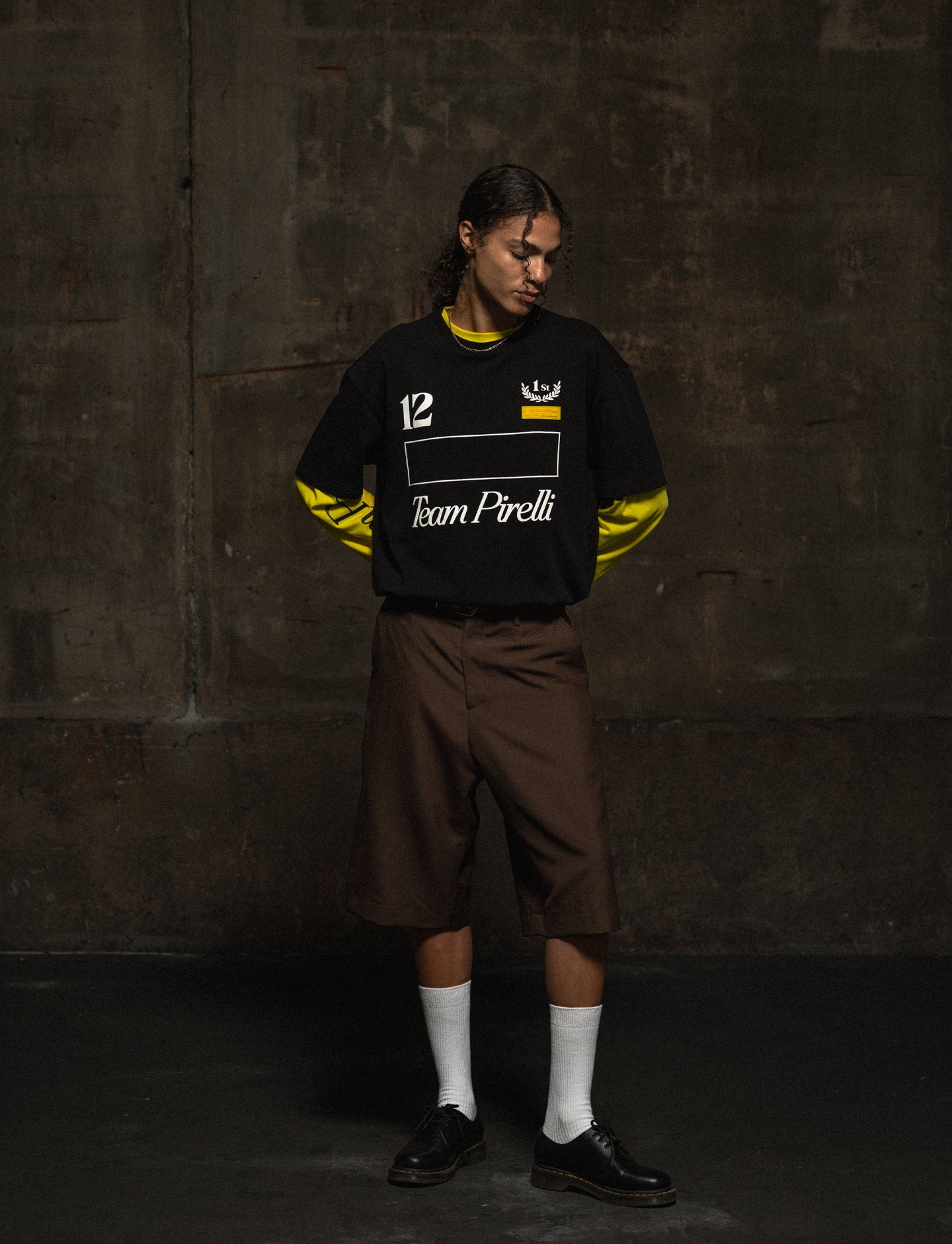 Person wearing a black and yellow sports outfit with 'Team Pirelli' text against a dark background