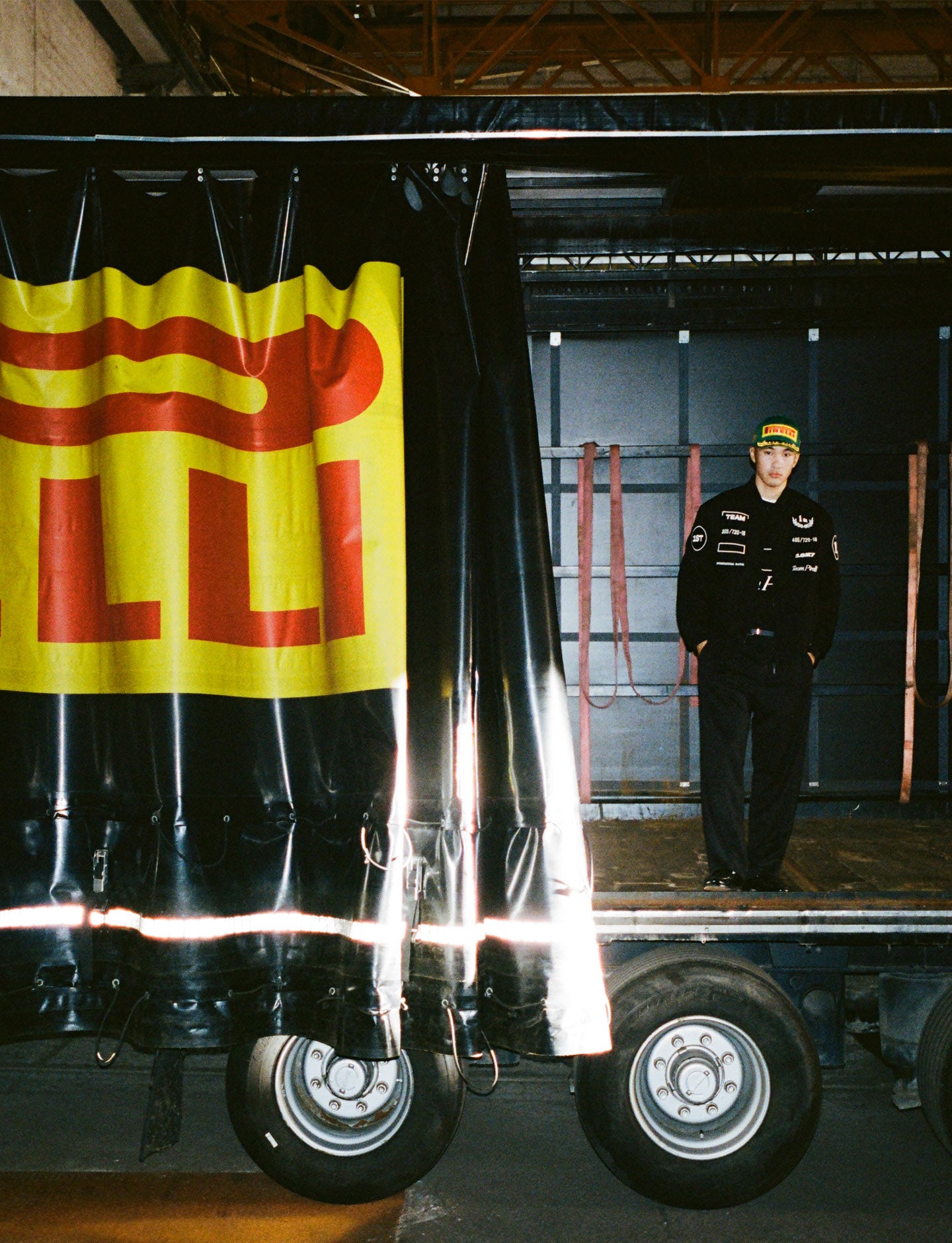 Person standing on a flatbed truck next to a Pirelli banner