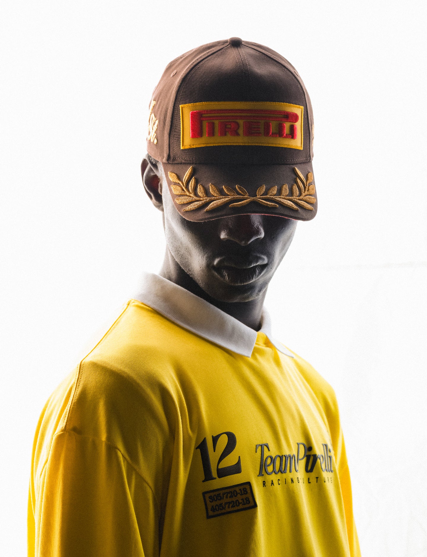 Person wearing a yellow rPirelli acing jersey and cap with Pirelli logo on a white background