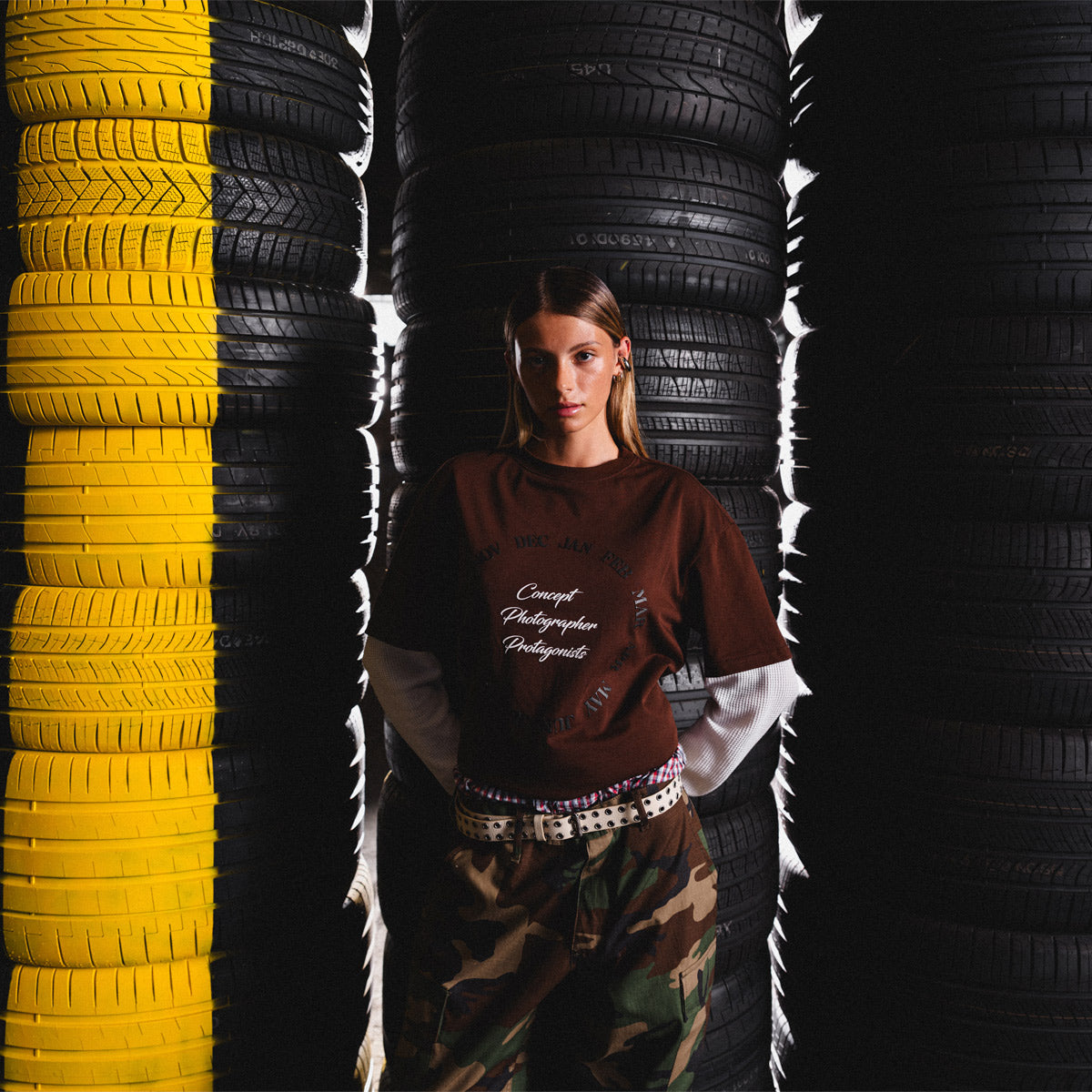 Person standing between stacks of yellow and black tires