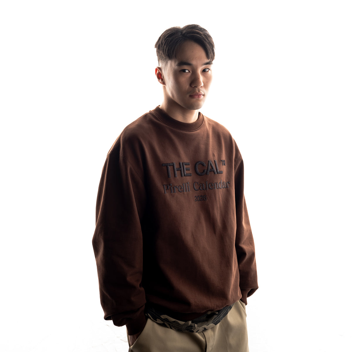 Person wearing a brown sweatshirt with 'THE CAL' branding on a white background