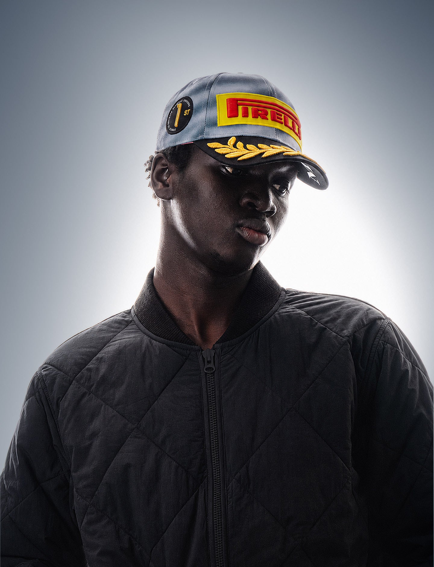 Person wearing a Miami 2026 F1® Pirelli Podium Cap on a blue faded background
