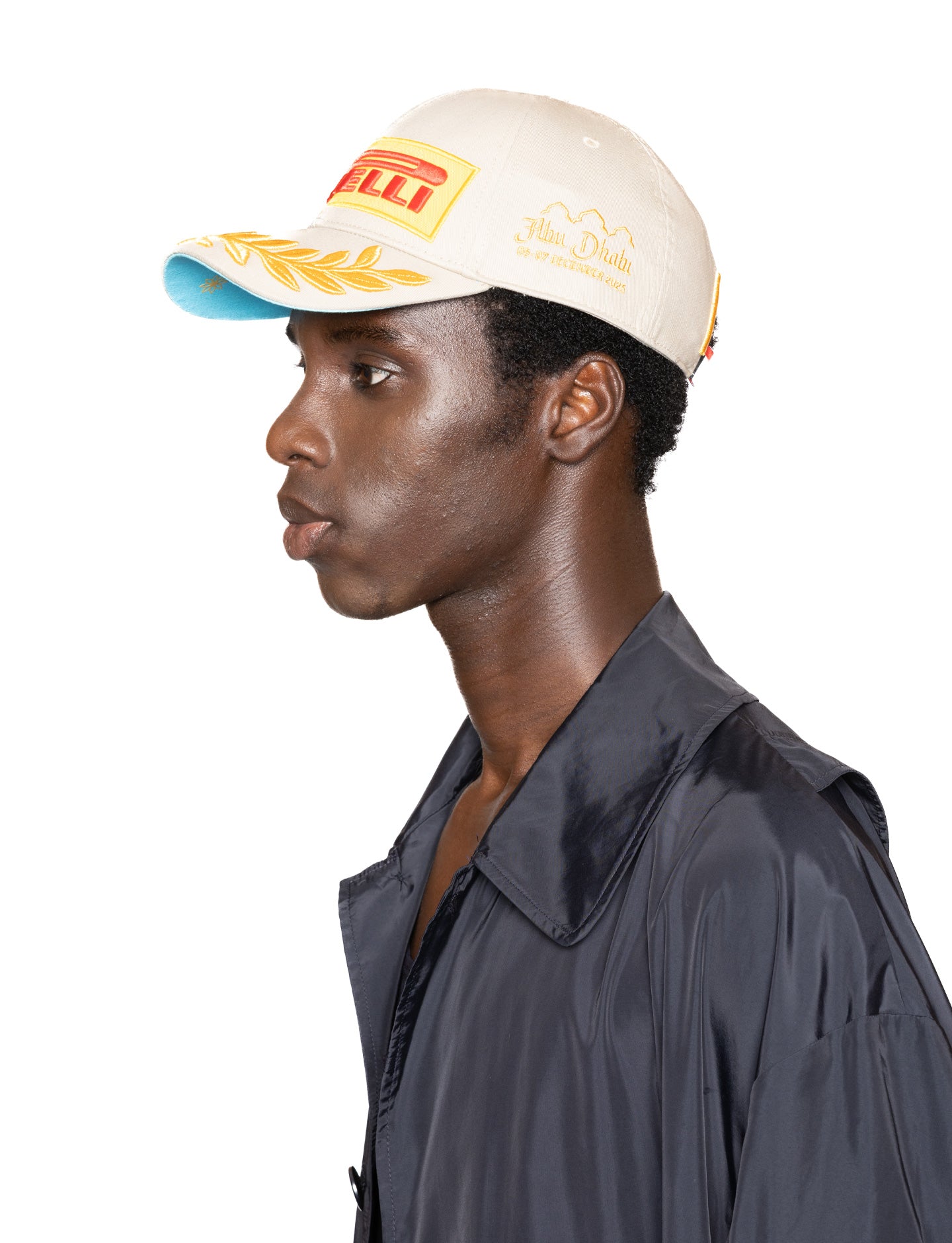 Person wearing a beige Pirelli cap side view
