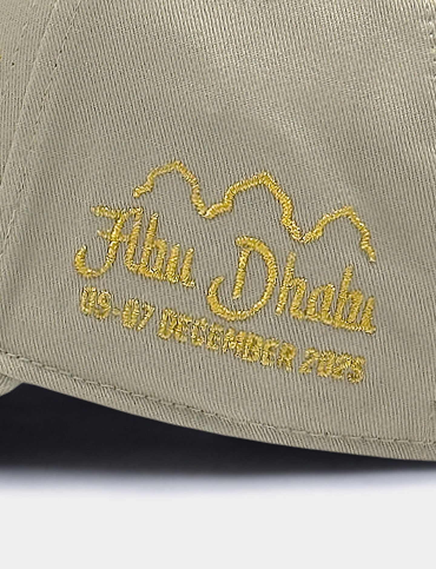 Beige cap with gold embroidered text on a light gray background