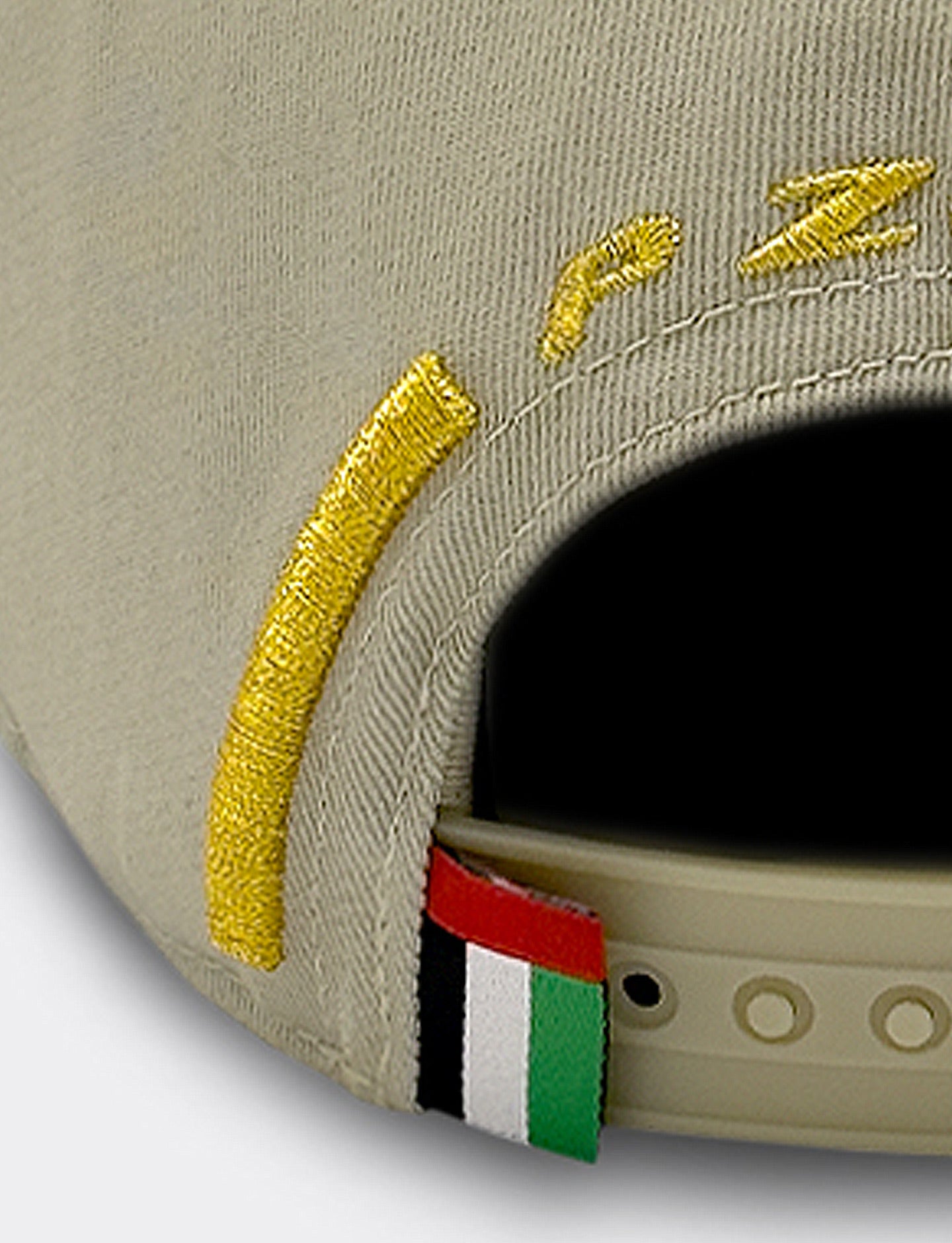 Beige cap with gold embroidery and a UAE flag label on a light gray background