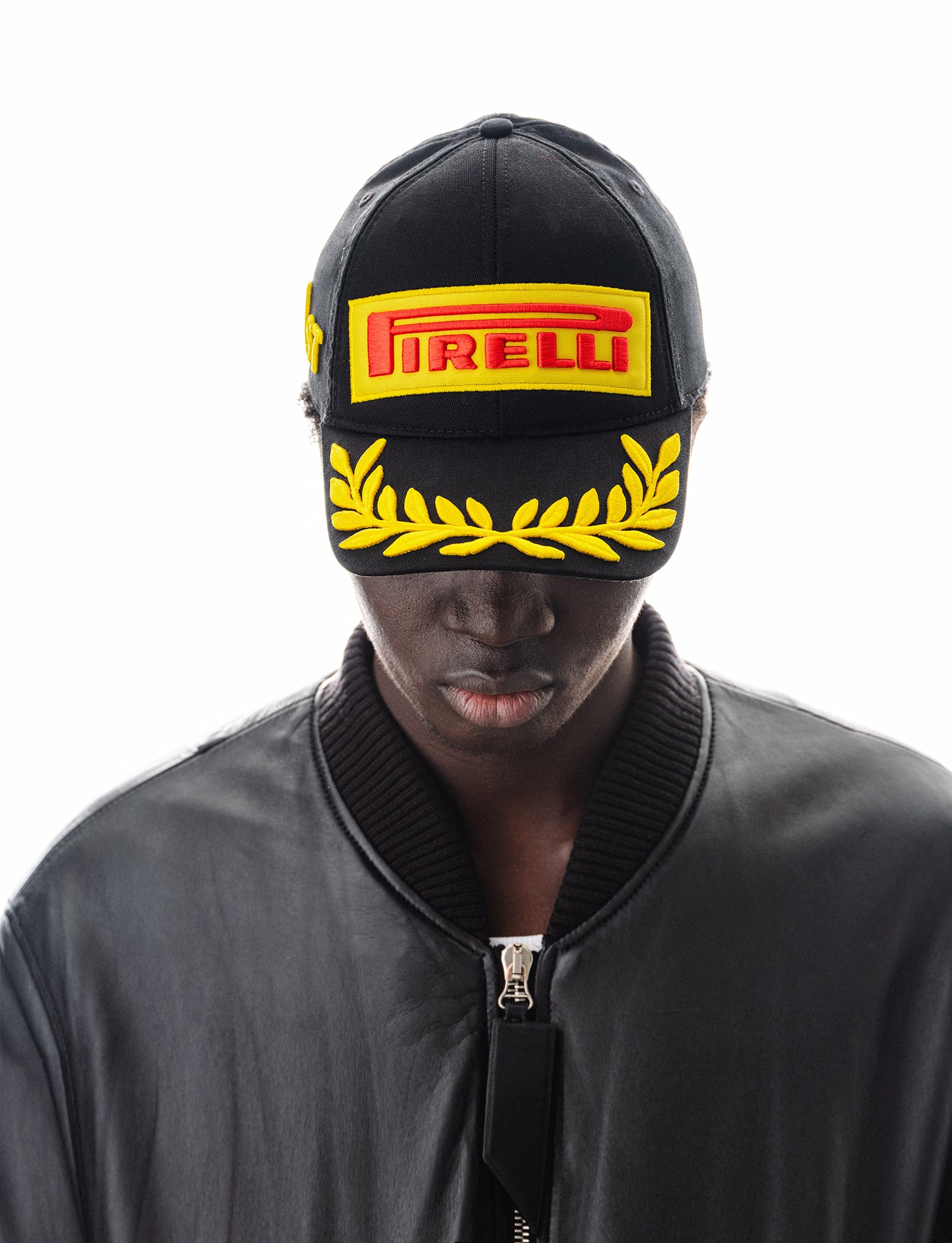 Person wearing a black Pirelli F1® Podium Cap on a white background