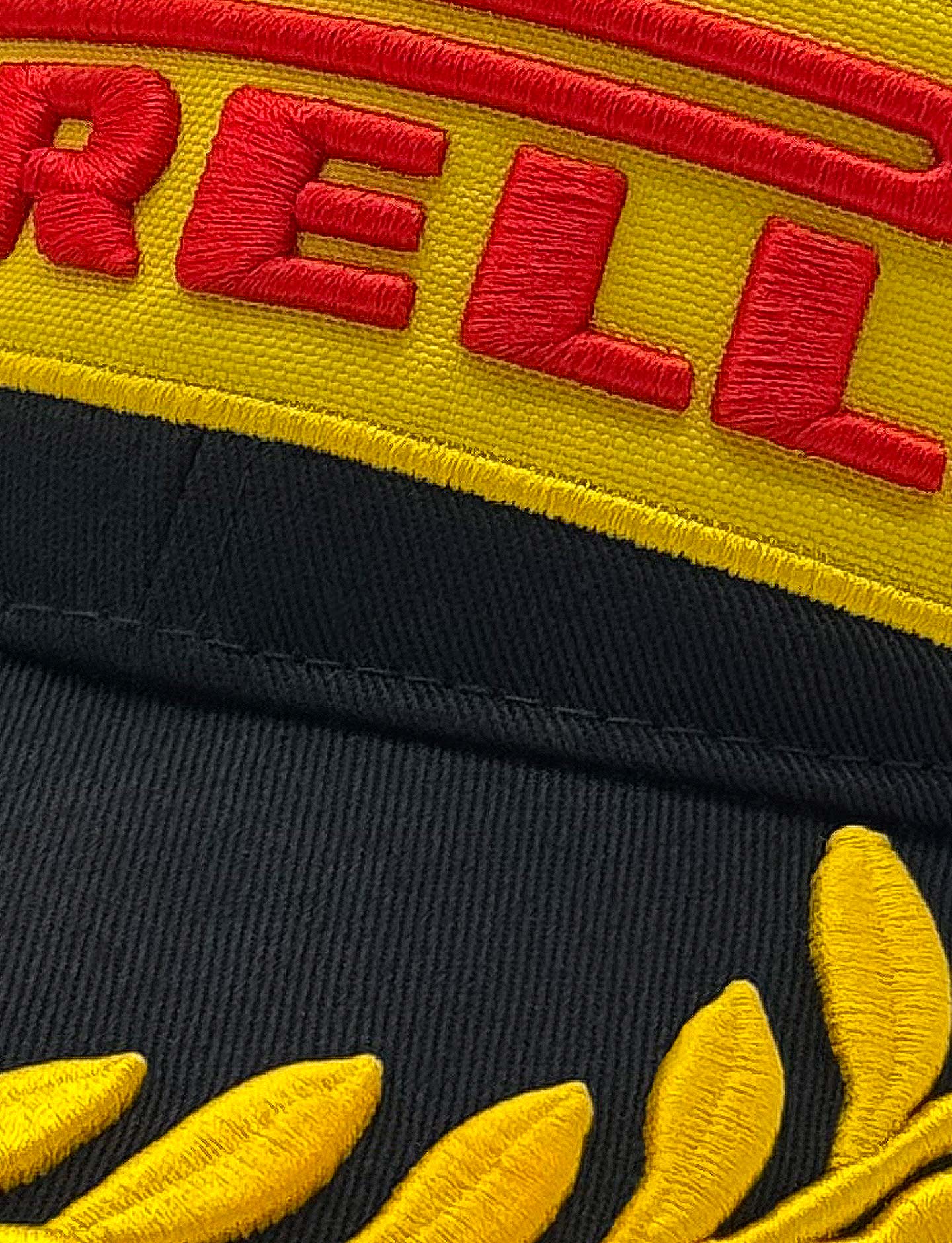 Close-up of a cap with red and yellow Pirelli branding on a black background