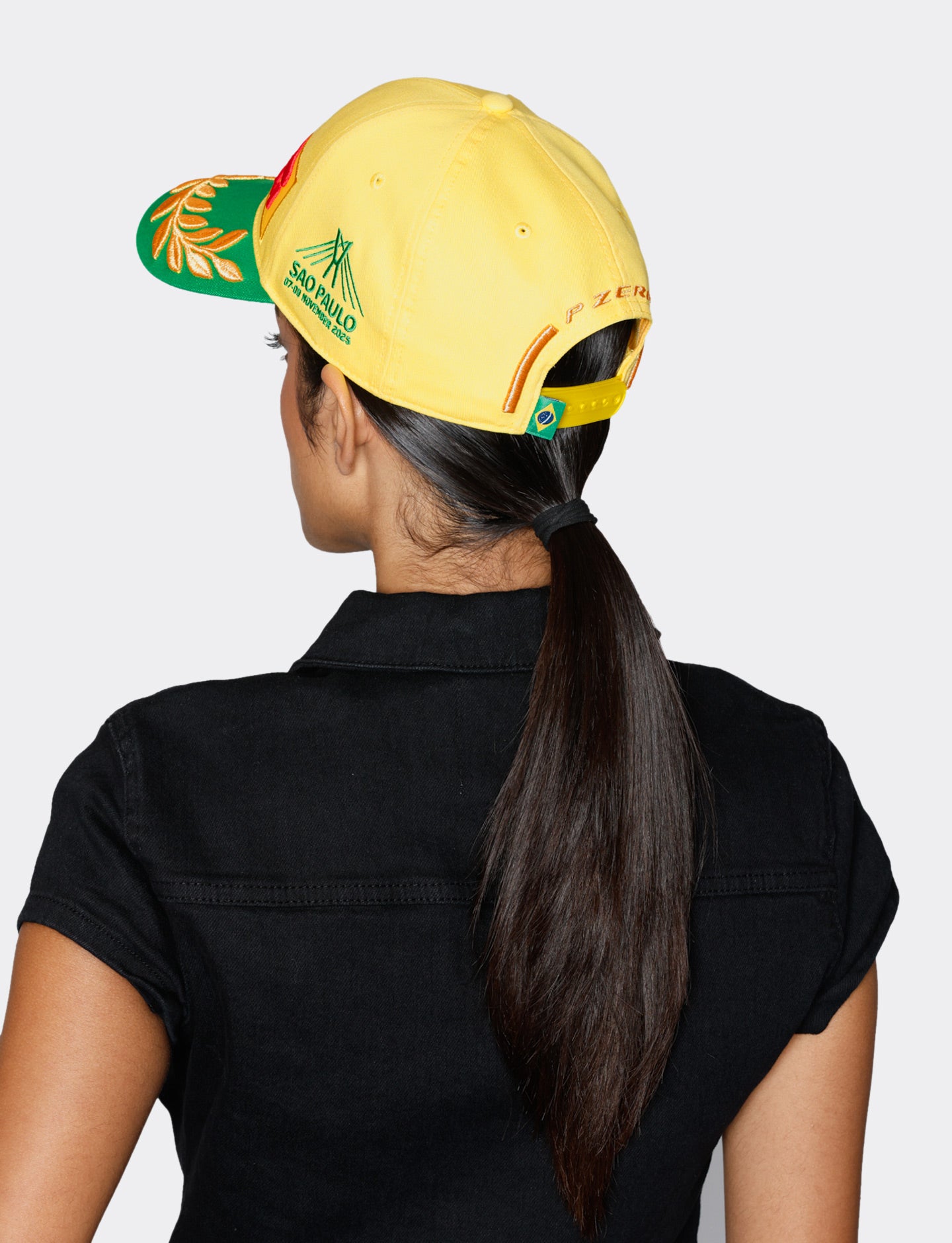 Person wearing a yellow cap with branding on a white background