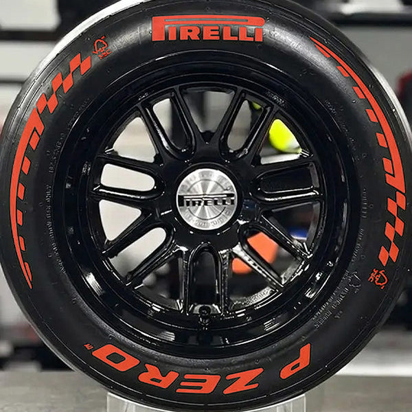 Close-up of a Pirelli racing tire with a black rim and red branding.
