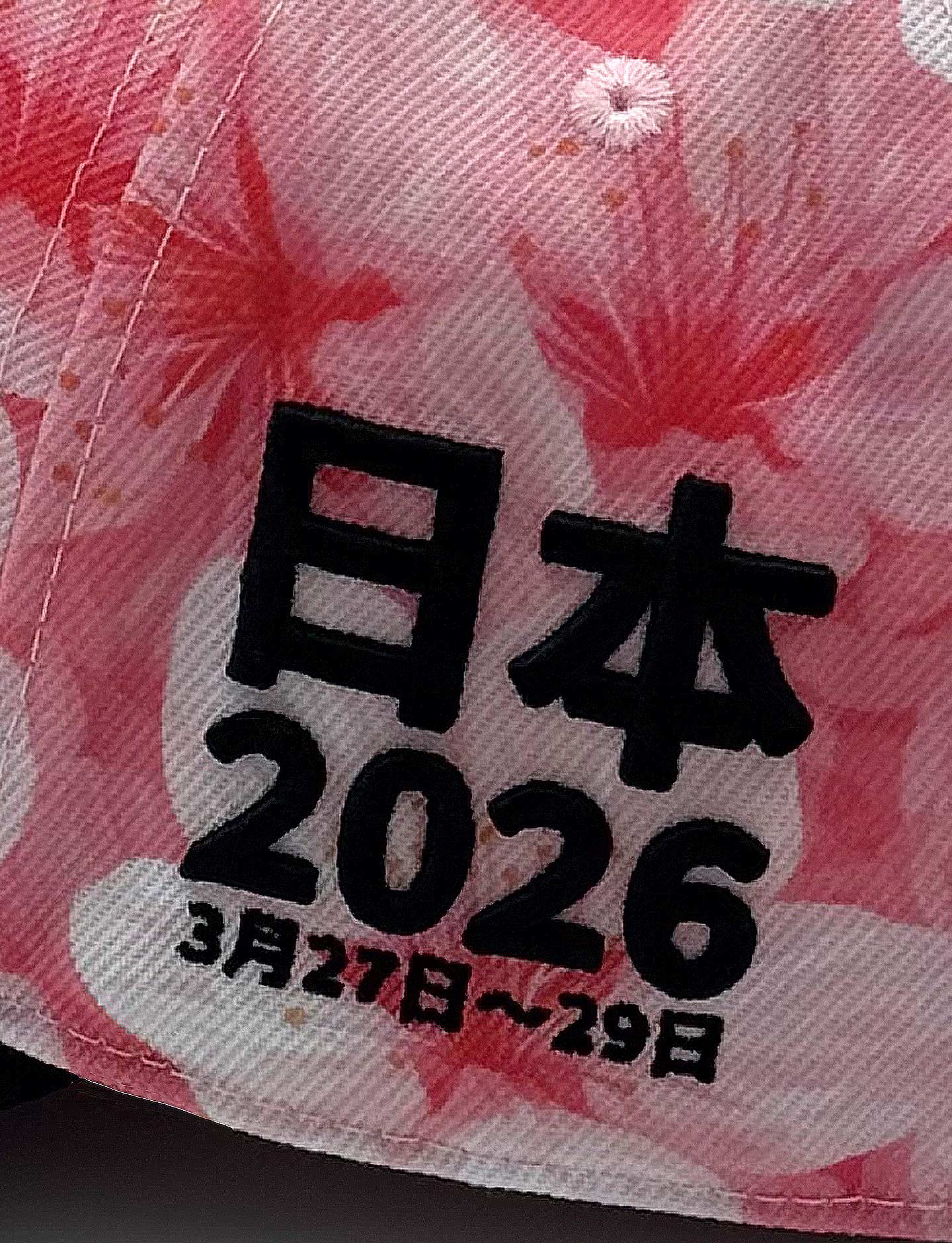 Text with '日本 2026' and dates on a pink floral patterned background
