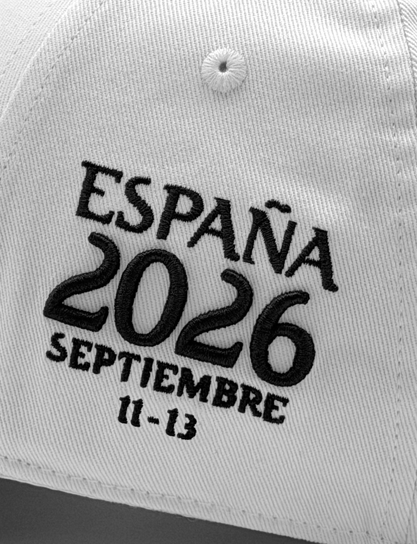 closeup of Pirelli Podium Cap 2026 Madrid showing 'ESPAÑA 2026 SEPTIEMBRE 11-13" black embroidery on left panel of cap