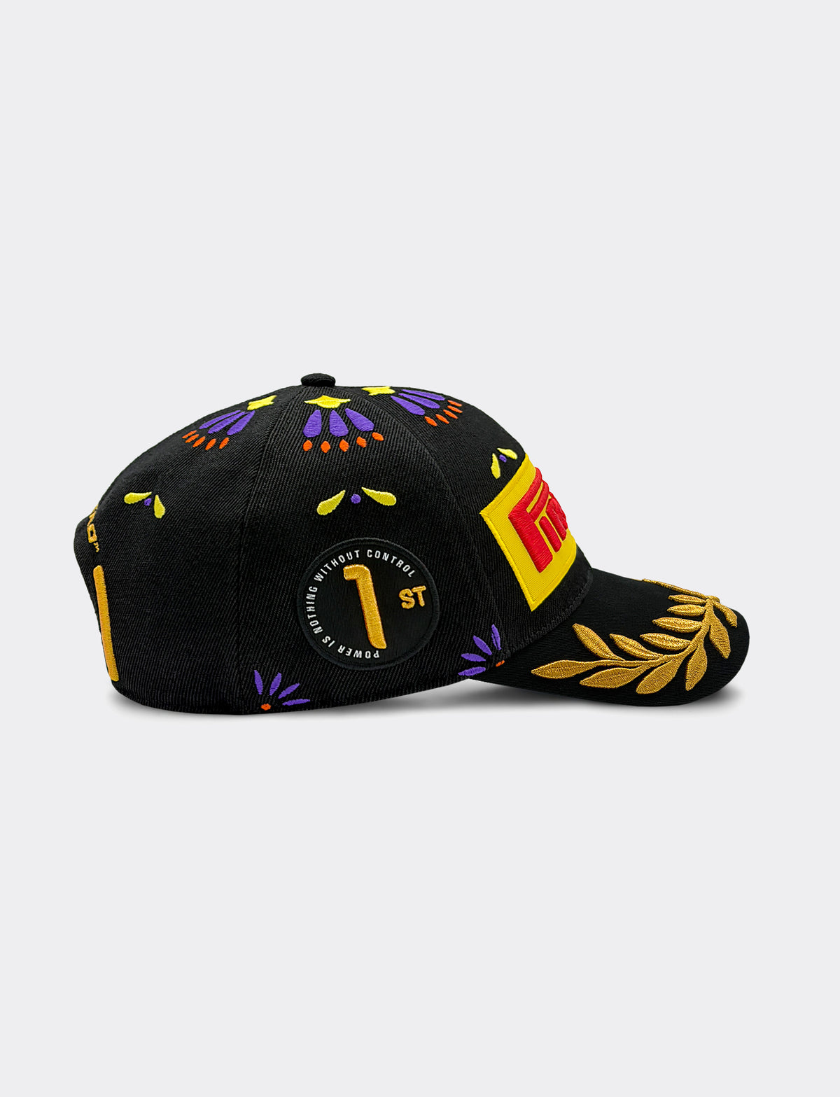 A black Pirelli Podium Cap 2026 Mexico featuring a colorful Mexican-style pattern with purple and yellow floral motifs, a circular black patch with a gold '1st' emblem, and a yellow laurel leaf design on the brim.