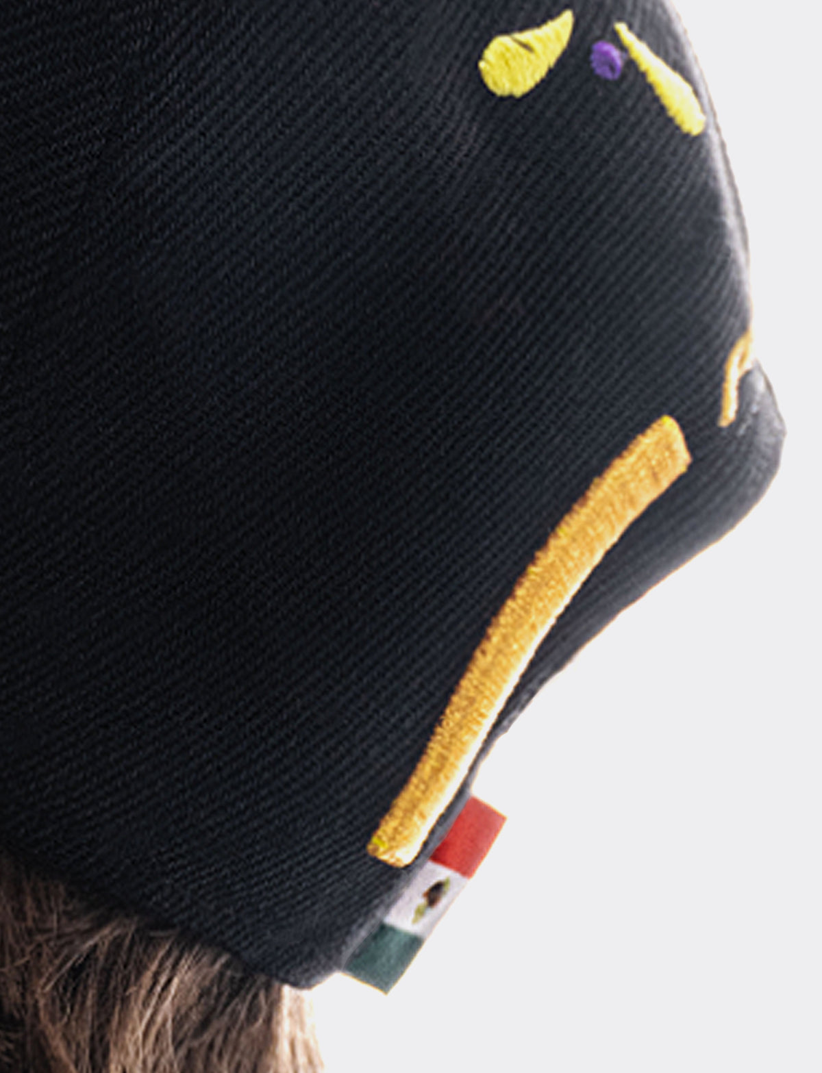 Closeup of black Pirelli cap with small Mexican flag on snapback closure