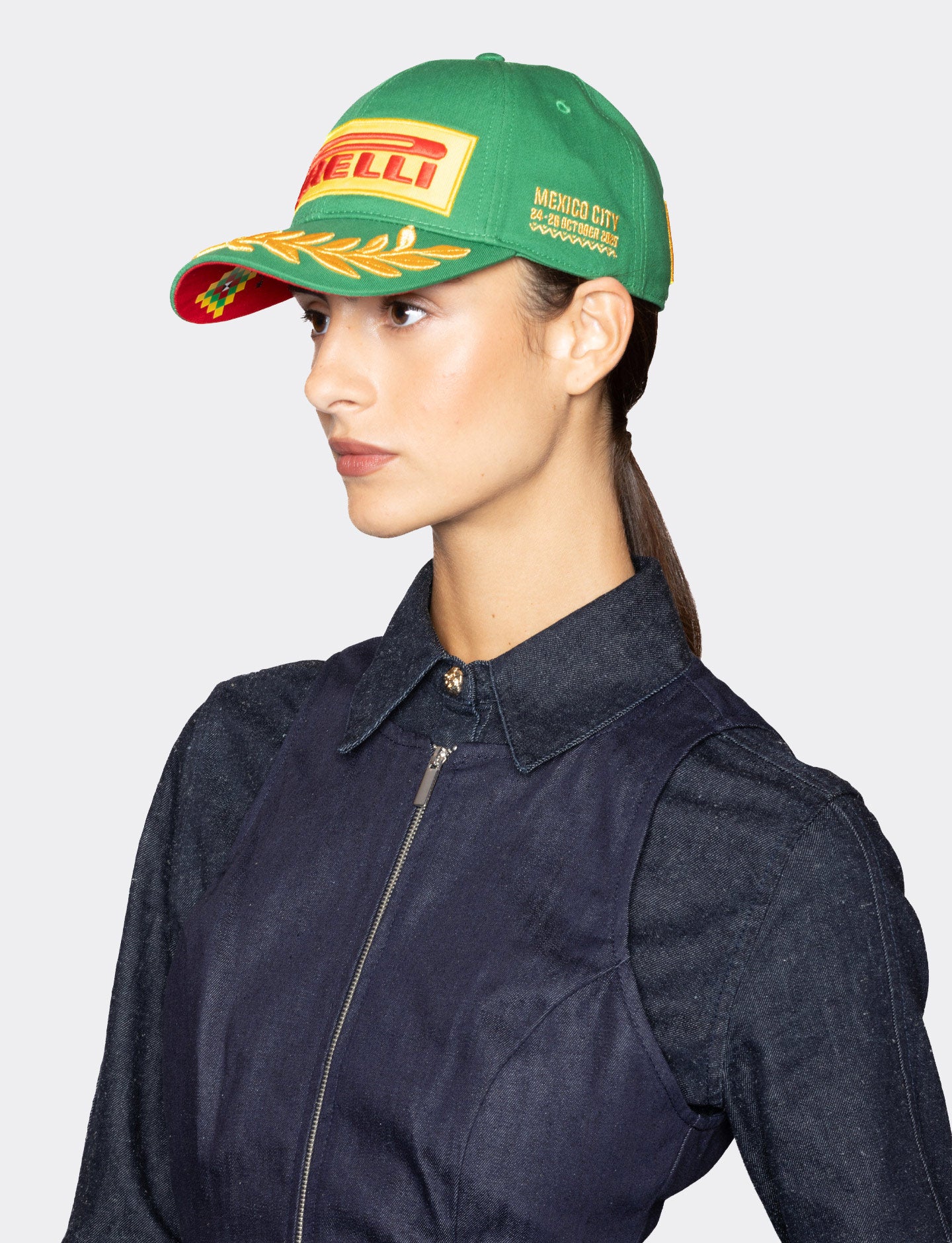 Person wearing a green cap with Pirelli logo on a white background