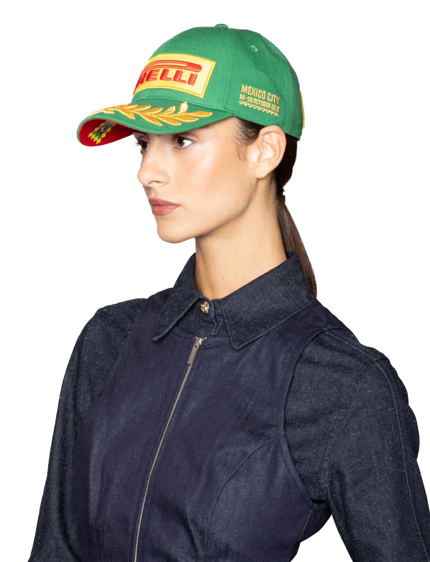 Person wearing a green cap with Pirelli logo on a white background