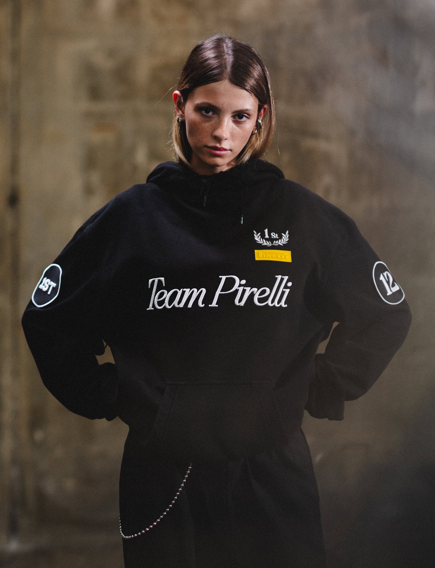 woman wearing Team Pirelli hoodie against dark background