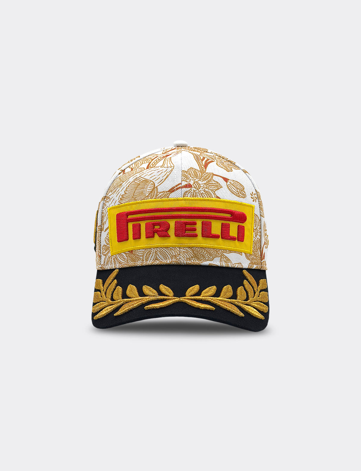 Front view of Pirelli Podium Cap 2026 Singapore featuring a white crown with orange/brown floral patterns, a black brim with gold leaf embroidery, and yellow and red graphic Pirelli logo.