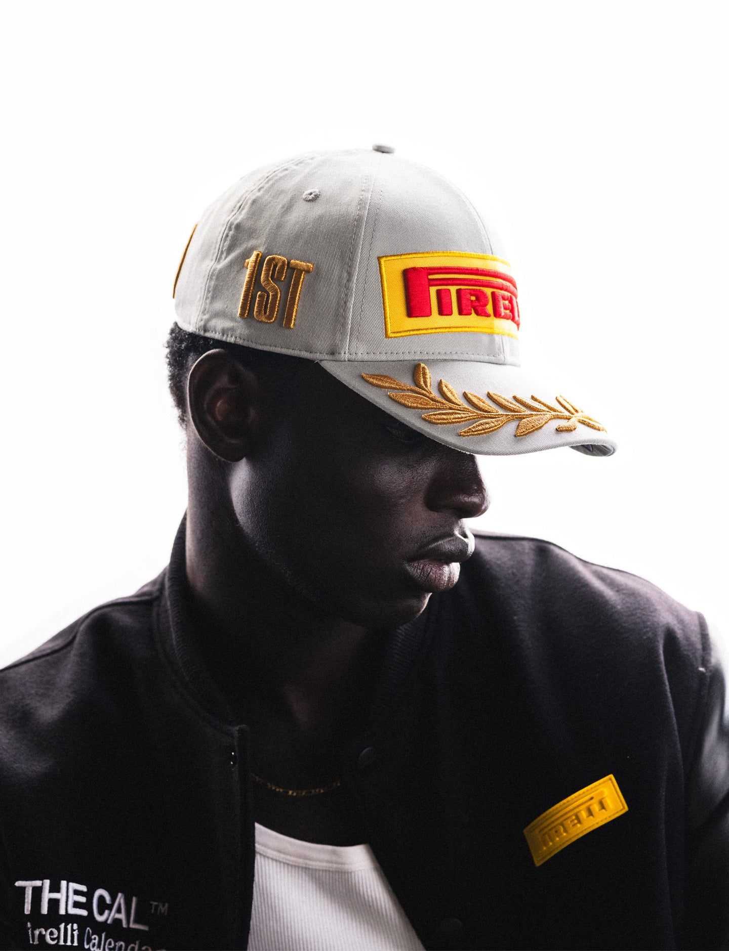 Person wearing a cap with Pirelli logo and a jacket with Pirelli The Cal branding on a white background