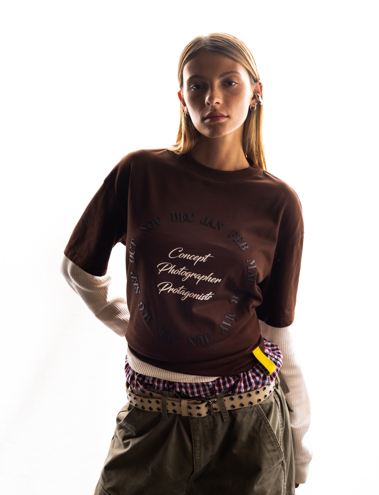 Woman wearing a brown Pirelli tee with text on a white background