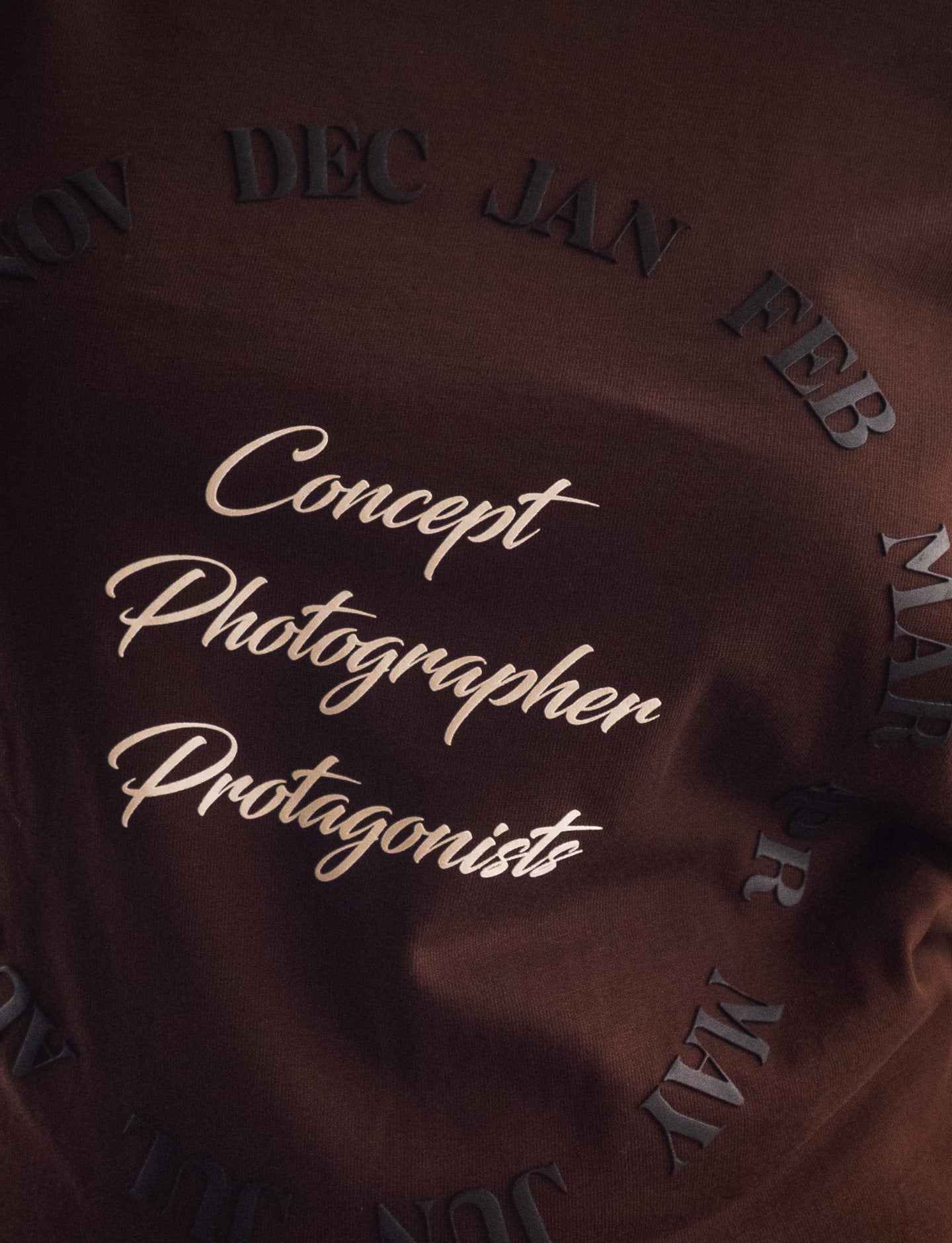 Brown Pirelli t-shirt with 'Concept Photographer Protagonist' text and month labels.