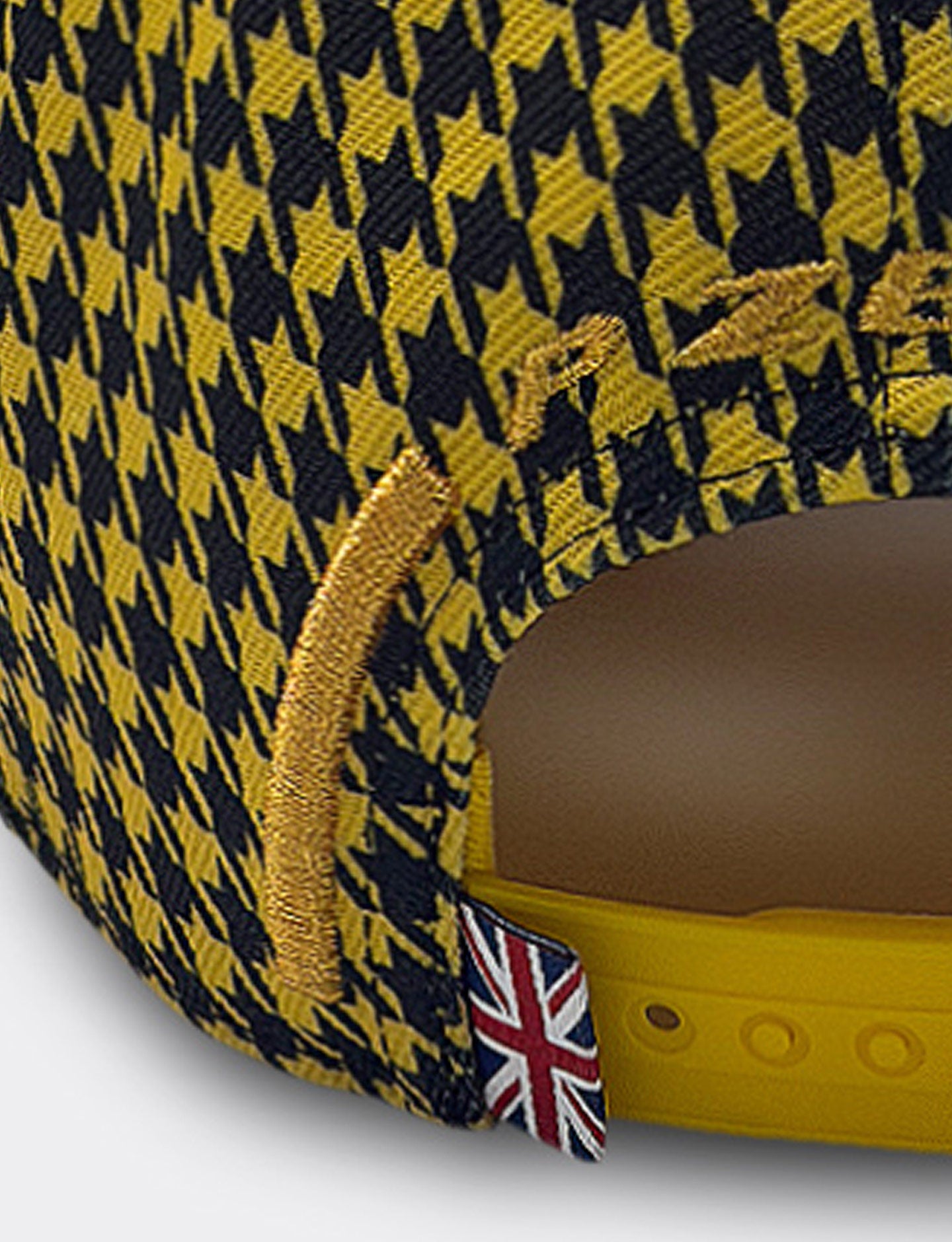 Close-up of a yellow and black Pirelli Podium Cap Silverstone 2026 F1® with a British flag label on snapback closure.