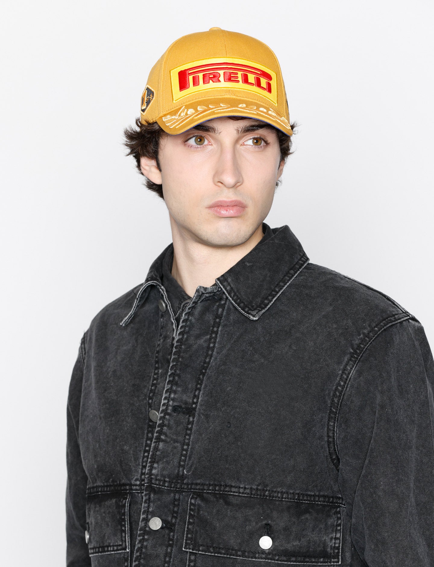 Man wearing gold Pirelli podium cap on white background