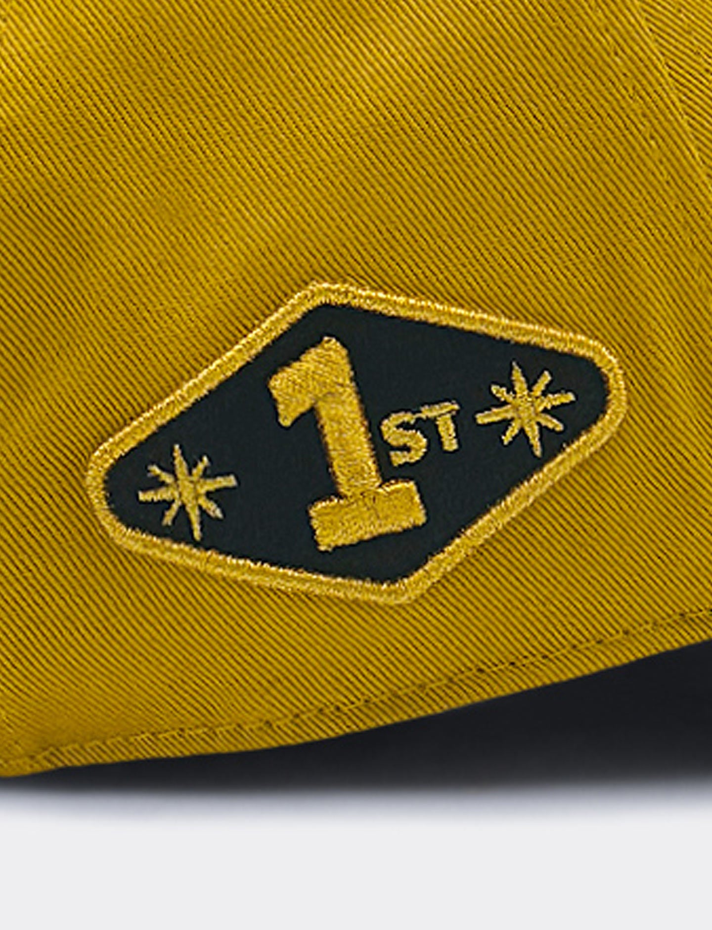Gold cap with a black and gold embroidered patch featuring the number '1'.