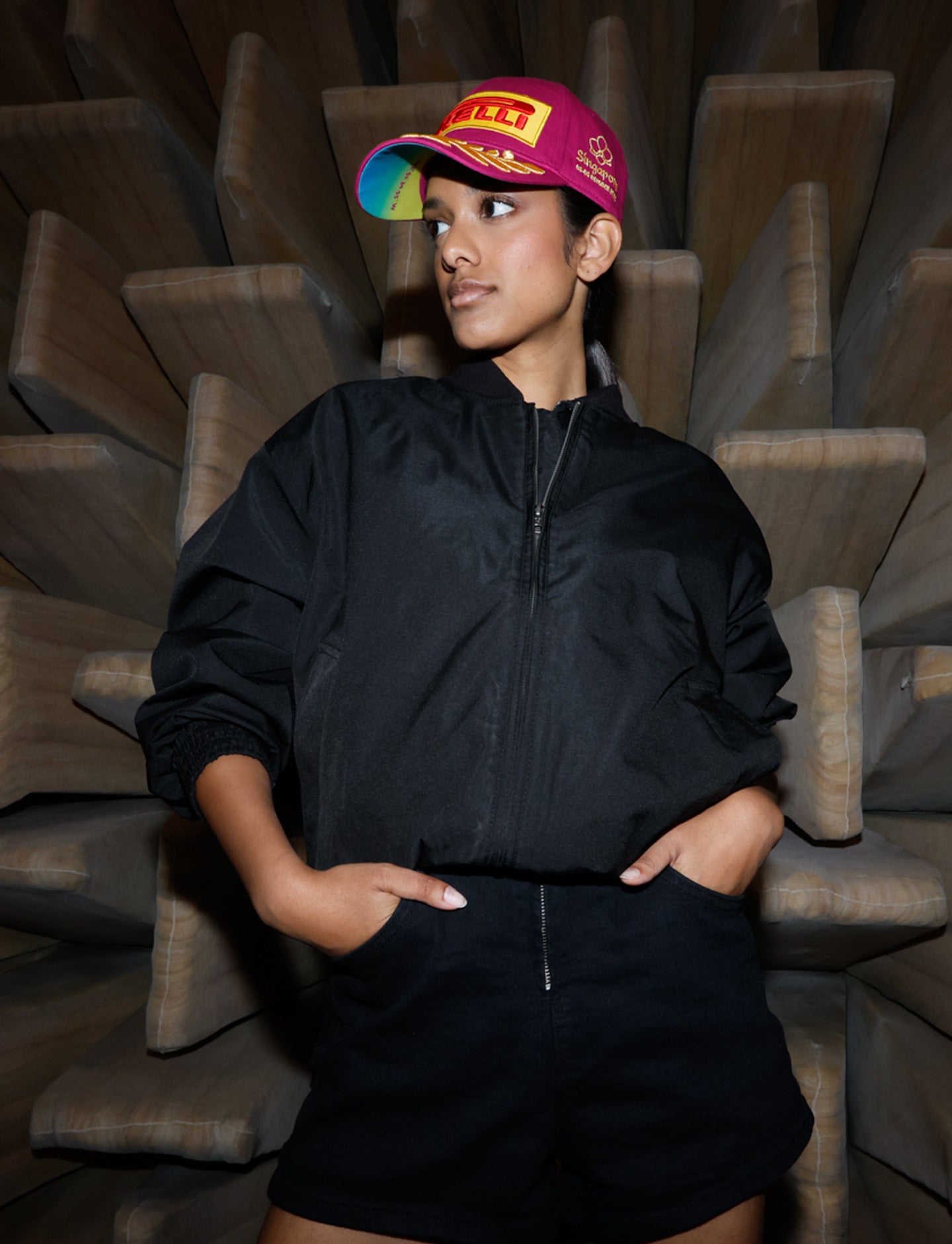 Person wearing a black outfit and magenta Pirelli podium cap
